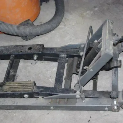Heavy-duty hydraulic motorcycle or ATV lift jack with foot pedal pump, showing minor wear and surface dust.