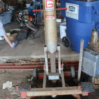 Vintage Gray Porta-Matic pneumatic air lift jack, showing age-appropriate wear and surface rust.