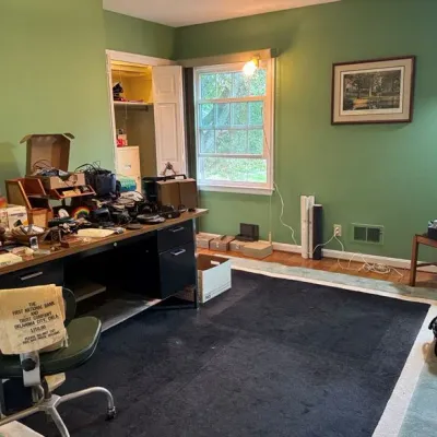 Sale Photo Thumbnail #20: mid-century executive desk, various electronics and small collectibles, green vinyl swivel chair and an area rug.