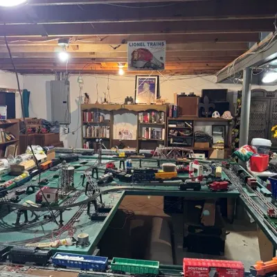 Sale Photo Thumbnail #14: Large model train layout featuring Lionel trains, multiple tracks, buildings, and accessories.