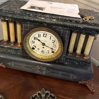 Sale Photo Thumbnail #26: Antique Seth Thomas Adamantine mantel clock featuring faux-marble finishes, columns, incised decoration, and a brass winding key.