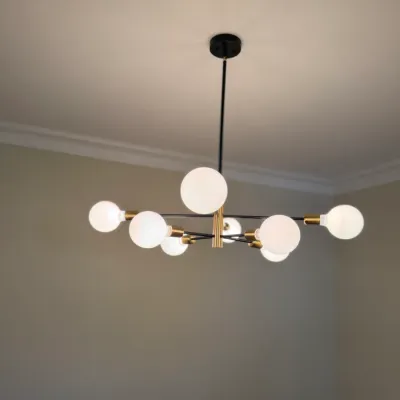 Sale Photo Thumbnail #24: Modern mid-century style sputnik chandelier with black and brass metal accents and exposed globe light bulbs.