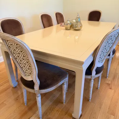 Sale Photo Thumbnail #16: Contemporary high-gloss cream dining table set with six French Provincial style chairs featuring whitewashed wood trim, brown velvet seat cushions, and geometric pattern upholstered backrests.