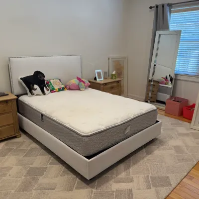 Sale Photo Thumbnail #107: Modern upholstered platform bed with nailhead trim headboard, flanked by light wood nightstands in a bedroom setting.