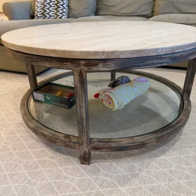 Sale Photo Thumbnail #12: Round rustic contemporary coffee table with a light stone top, distressed dark wood frame, and a glass lower display shelf.