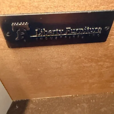 Sale Photo Thumbnail #96: Black metal manufacturer tag reading 'Liberty Furniture Industries, Inc.' inside a wooden drawer.