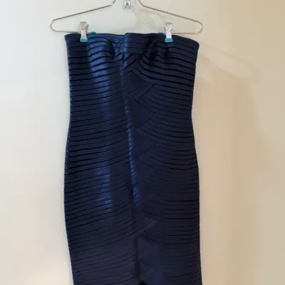 Sale Photo Thumbnail #71: Navy blue strapless bandage-style cocktail dress with horizontal pleated detail, hanging on a metal hanger.