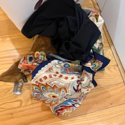 Sale Photo Thumbnail #76: Assorted vintage and modern scarves spilled onto a wooden floor next to a white laundry basket, including a multi-colored paisley scarf with an Echo brand tag.