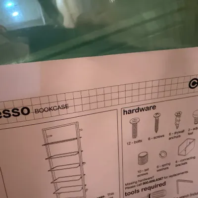 Sale Photo Thumbnail #90: Glass shelving panels for a modern CB2 Tesso bookcase, shown alongside original assembly instruction manual.