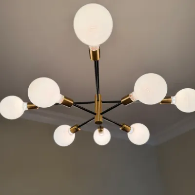 Sale Photo Thumbnail #23: Mid-century modern style sputnik chandelier featuring black metal arms with brass sockets and globe light bulbs.