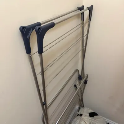 Sale Photo Thumbnail #75: Polder metal folding laundry drying rack leaning against a wall, in clean, gently used condition.