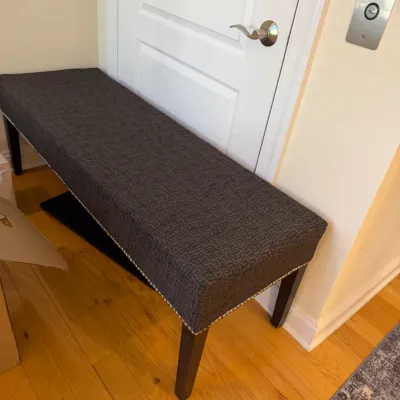 Sale Photo Thumbnail #39: Modern upholstered entryway bench with dark patterned fabric trim, silver nailhead detailing, and dark wood legs.