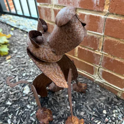 Sale Photo Thumbnail #95: Rustic metal dog sculpture crafted from scrap iron with a weathered, rusted patina, designed as garden or lawn art.