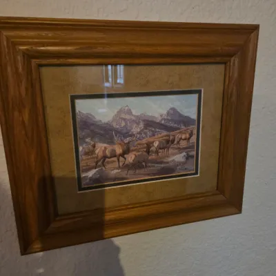 Sale Photo Thumbnail #86: Framed wildlife art print depicting a herd of elk in a mountainous landscape, housed in a thick molded wooden frame with double matting.