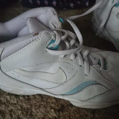 Sale Photo Thumbnail #5: Vintage white Nike high-top sneakers with turquoise accents, showing light wear and scuffing.