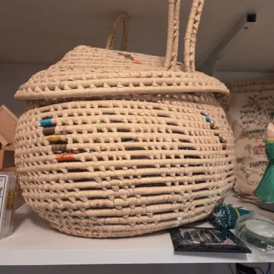 Sale Photo Thumbnail #136: Handwoven straw sewing basket with lid, long loop handles, and colorful thread spool accents integrated into the weave.