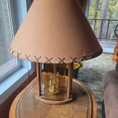 Sale Photo Thumbnail #76: Rustic table lamp with a three-bulb candelabra base, smoked glass panels, and a faux-leather shade with whipstitched details.