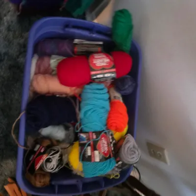 Sale Photo Thumbnail #126: Purple plastic storage bin filled with various skeins of colorful crafting yarn, including Red Heart brand.