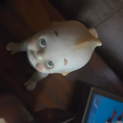 Sale Photo Thumbnail #107: Vintage bisque Kewpie-style crawling baby figurine featuring hand-painted facial details and a topknot.
