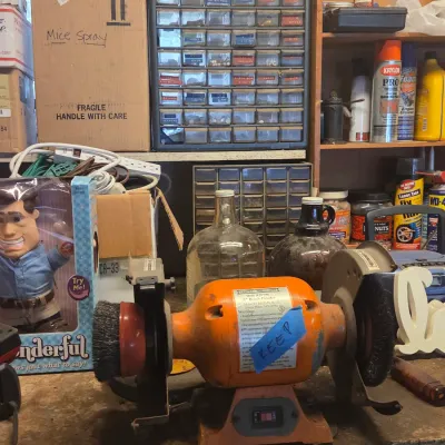Sale Photo Thumbnail #49: Central Machinery 6-inch bench grinder with wire wheels, set on a cluttered workshop workbench.