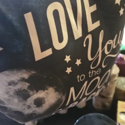 Sale Photo Thumbnail #9: Black throw pillow featuring white typography reading 'LOVE YOU to the MOON AND BACK' alongside stars and a full moon graphic.