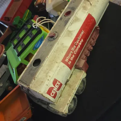 Sale Photo Thumbnail #21: Vintage pressed steel Cenex tanker trailer toy, showing heavy play wear, paint loss, and surface residue.