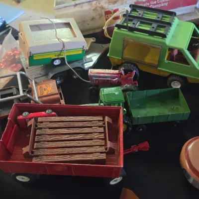 Sale Photo Thumbnail #52: Collection of vintage press-steel and plastic toy vehicles, including a lime green Tonka camper truck, a red wagon with fence inserts, and various tractors.