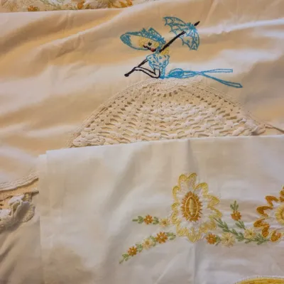 Sale Photo Thumbnail #60: Vintage embroidered linens, featuring a southern belle with a crochet skirt accent and floral motif pillowcases with crocheted trim.