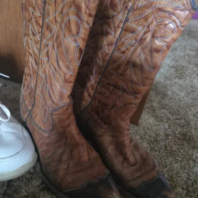 Sale Photo Thumbnail #2: Pair of vintage light brown leather cowboy boots featuring western stitching and contrasting dark toes.