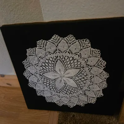 Sale Photo Thumbnail #92: Framed vintage lace doily with a floral motif mounted on black velvet background.
