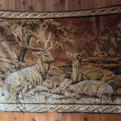 Sale Photo Thumbnail #158: Vintage woven wall tapestry depicting deer resting in a forest, rendered in warm brown and tan earth tones with a scrollwork border.