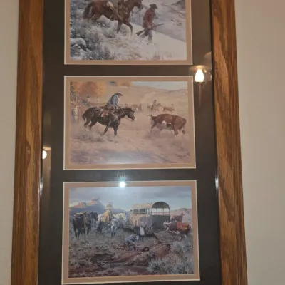 Sale Photo Thumbnail #68: Framed triptych of Western art prints featuring cowboys and horses, mounted in a dark mat and medium oak wooden frame.