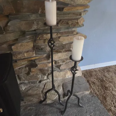 Sale Photo Thumbnail #79: Pair of black wrought iron floor candlestick holders with twisted metal accents, topped with flameless pillar candles.