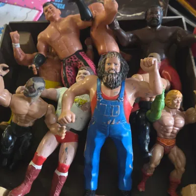 Sale Photo Thumbnail #55: Collection of vintage 1980s wrestling and action figures, including LJN WWF wrestlers and a Masters of the Universe He-Man figure in played-with condition.