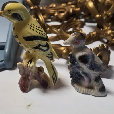 Sale Photo Thumbnail #8: Pair of vintage hand-painted ceramic bird figurines, including a yellow songbird perched on a stump and a smaller blue and white bird.