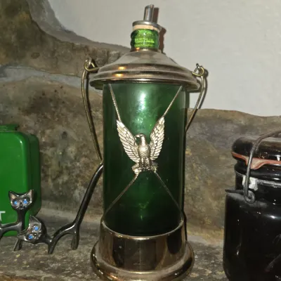 Sale Photo Thumbnail #72: Vintage green glass decanter styled like a lantern with brass-tone hardware, an eagle emblem, and a metal pour spout.