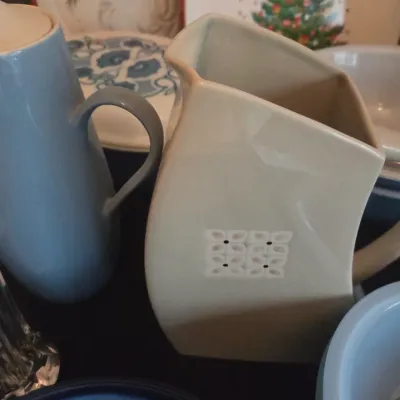 Sale Photo Thumbnail #115: Collection of vintage ceramics, including a mid-century geometric beige pitcher with raised detailing and a light blue ceramic coffee pot.