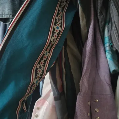 Sale Photo Thumbnail #3: Selection of vintage western-style snap-button shirts and jackets hanging on a rack, featuring patterned trim and metal snap closures.