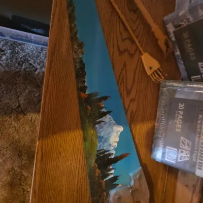 Sale Photo Thumbnail #89: Hand-painted vintage hand saw featuring a scenic mountain landscape with pine trees.