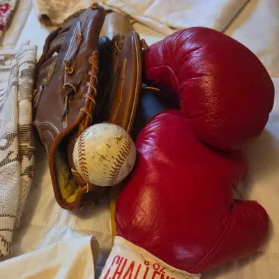 Sale Photo Thumbnail #61: Vintage sporting equipment collection featuring a pair of red Challenger 8 oz boxing gloves, a worn baseball, and a brown leather baseball glove.