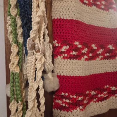 Sale Photo Thumbnail #132: Hand-crafted macramé plant hangers with wooden beads alongside a vintage red, cream, and brown crocheted afghan blanket.