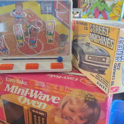 Sale Photo Thumbnail #53: Collection of vintage 1970s and 1980s toys, including a Tomy basketball game, a boxed AMT '68 Camaro model kit, and a Kenner Easy-Bake Mini-Wave Oven in its original box.