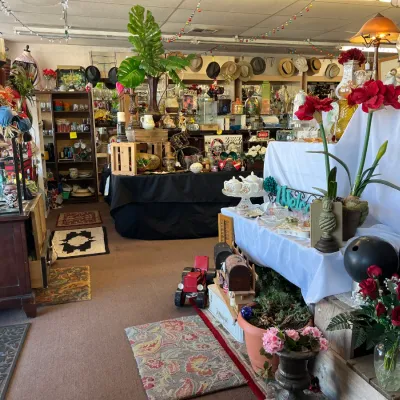 Sale Photo Thumbnail #5: Retail store display filled with a variety of vintage decor items, artificial flowers, lamps, glassware, and collectibles.