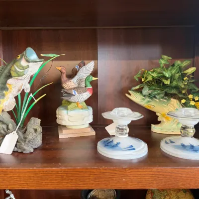 Sale Photo Thumbnail #4: Collection of decorative shelf items including fish and mallard duck figurines alongside a pair of hand-painted glass candlestick holders.