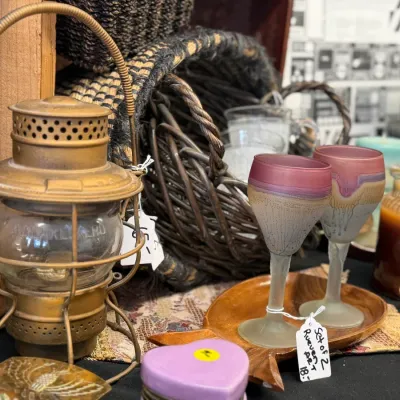 Sale Photo Thumbnail #20: Vintage brass Adlake Kero railroad lantern with clear glass globe alongside a pair of frosted glass art stemware goblets.
