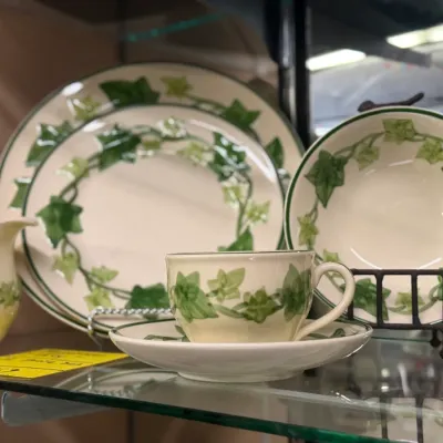 Sale Photo Thumbnail #36: Franciscan Ivy ceramic dinnerware pieces, including plates, a bowl, a teacup with saucer, and a cream pitcher.