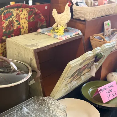 Sale Photo Thumbnail #38: Rustic distressed wooden bread box alongside various kitchenware, including a dark nonstick stockpot, clear glass dish, and green enamelware plates.