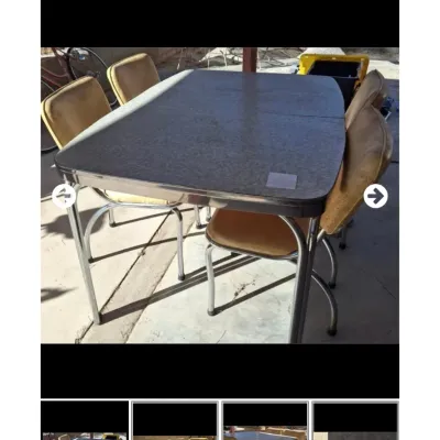 Vintage mid-century chrome dinette table with a gray Formica top, set with four matching vinyl-upholstered chairs showing some...