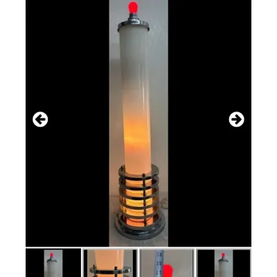 Vintage Art Deco style chrome floor lamp featuring a frosted cylinder body, stepped tiered base, and a small red bulb topper.