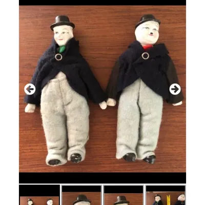 Pair of vintage porcelain-headed Charlie Chaplin figures dressed in fabric suits and bowler hats.